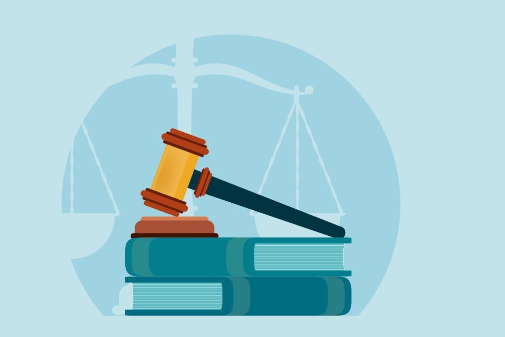 gavel resting on books with outline of scales of justice behind.