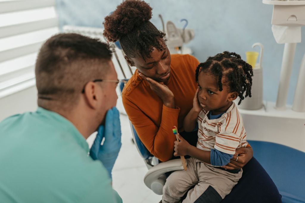 child and parent at dentist with child in pain